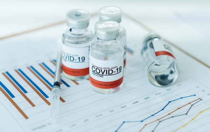 Covid 19 yazılı aşı şişeleri ve enjektör